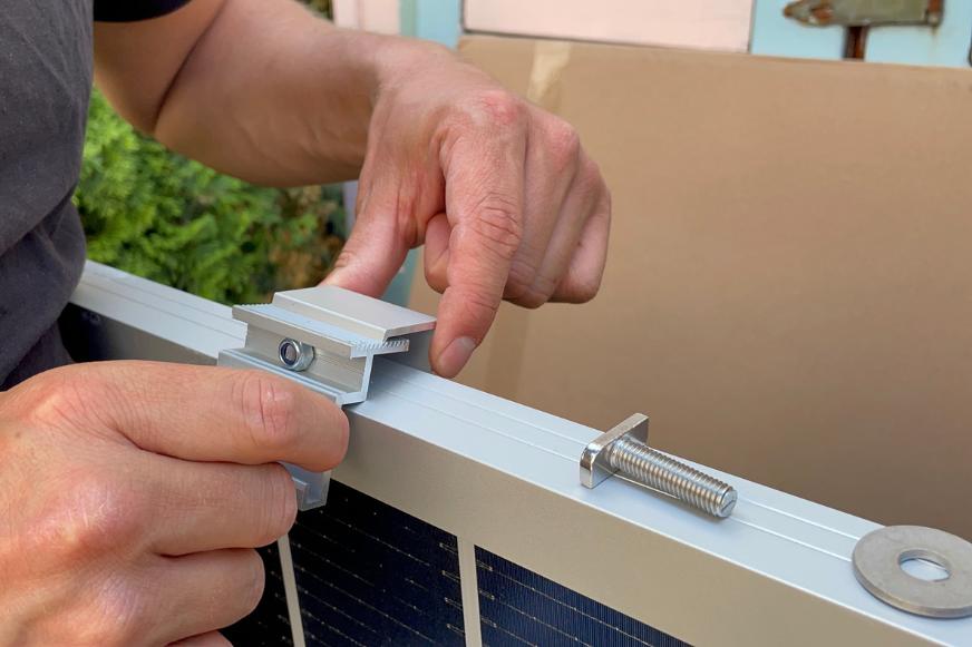 Die Halterungen für den Hoymiles HMS-800W-2T Mikrowechselrichters des Yuma Flat XL Balkonkraftwerks werden im Test an dem Solarmodul angbracht.